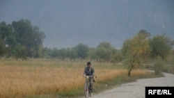 Afghanistan---Afghan Youth villager is riding on his bicycle in their forms in his village, 07November 2009 