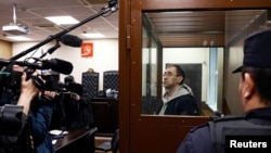 Oleg Roldugin, an investigative journalist for the independent Russian newspaper Novaya Gazeta, stands inside an enclosure for defendants before a court hearing in Moscow on April 10.