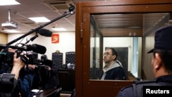 Oleg Roldugin, novinar nezavisnog ruskog lista Novaya Gazeta, stoji u ograđenom prostoru za optužene tokom sudskog ročišta u Moskvi, 10. aprila.