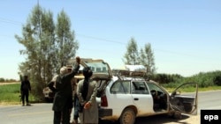 FILE: Afghan soldiers check a vehicle on a road in Helmand's Greshk district.