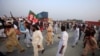 Supporters of Pakistani opposition leader Imran Khan run from tear gas as clashes begin between police and protesters in Swabi on October 31.