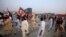 Supporters of Pakistani opposition leader Imran Khan run from tear gas as clashes begin between police and protesters in Swabi on October 31.
