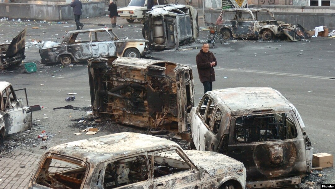 Armenia - A man walks past burned cars on a street in Yerevan where security forces clashed with opposition protesters, 2 March 2008.