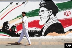 A man walks past a mural depicting late Iranian supreme leader Ayatollah Ali Khamenei in Tehran on July 24.