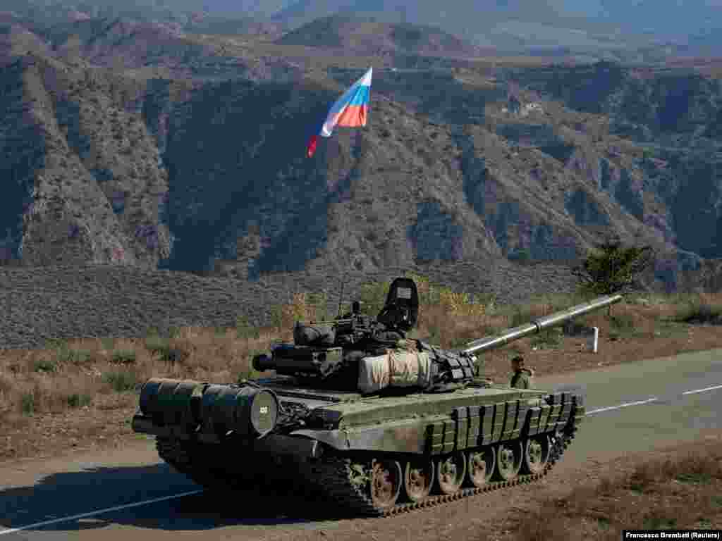 Участник российских миротворческих сил стоит рядом с танком недалеко от границы с Арменией после подписания соглашения о прекращении вооруженного противостояния между Азербайджаном и армянами в Нагорном Карабахе.