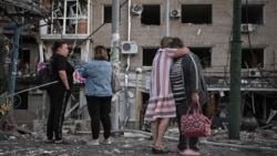 Residents observe the damage to an apartment building in Zaporizhzhya after a Russian air attack on August 30.