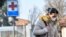 Жена с предпазна маска в Кодоно, един от 10-те града в Северна Италия, където властите призоваха гражданите да не излизат от къщи