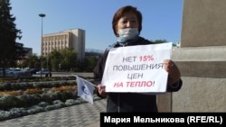 Жительница города Уральска Кадиша Муканова стоит на площади перед акиматом с плакатом против повышения тарифов. Уральск, 23 сентября 2020 года. 