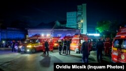 Ambulanțe așteptând la Clubul Colectiv, în seara incendiului