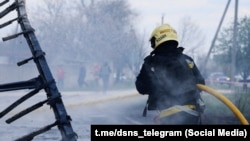 Vatrogasac gasi požar posle ruskog raketnog napada na ukrajinski grad Dnjepar, 14. april 2026.