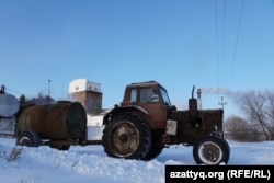 Трактор с цистерной, наполненной бардой, на фоне спиртзавода. 26 февраля 2021 года.