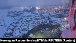 Поглед од спасувачки хеликопотер во градот Аск, каде што голем одрон однесе најмалку осум домови .
