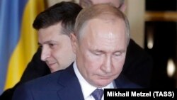 Ukrainian President Volodymyr Zelenskiy stands behind Russian President Vladimir Putin after they met face-to-face for the first time at talks in Paris on December 9 aimed at ending the conflict in eastern Ukraine.