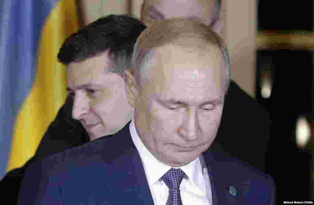 Ukrainian President Volodymyr Zelenskiy stands behind Russian President Vladimir Putin after they met face-to-face for the first time at talks in Paris on December 9 aimed at ending the conflict in eastern Ukraine. The two agreed to “commit to a full and comprehensive implementation” of a cease-fire by the end of 2019, a joint communique said. (TASS/Mikhail Metzel)