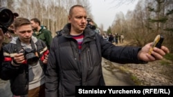 Працівник Чорнобильської зони вимірює радіаційний фон на околиці Рудого лісу під час візиту до нього українських журналістів