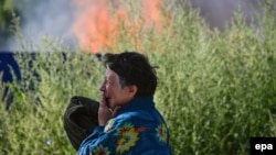 Жінка плаче поряд з її будинком, який був зруйнований під час бойових дій у Слов'янську, 30 червня 2014 року