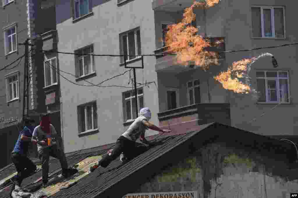 A left-wing militant throws a Molotov cocktail during clashes with Turkish riot police in Istanbul's Gazi district. (AFP/Bulent Kilic)