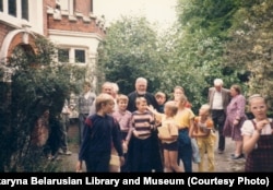 Чарнобыльскія дзеці на адпачынку ў Беларускім рэлігійным і культурным цэнтры ў Лёндане. У цэнтры фота — айцец Аляксандар Надсан. Пачатак 1990-х. З калекцыі Беларускай бібліятэкі і музэю імя Францішка Скарыны ў Лёндане