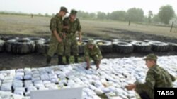 Guards at the Tajik-Afghan border sort seized heroin. 