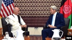 A handout picture released by the US Department of State shows US Secretary of State John Kerry (R) sits with Afghan presidential candidate Ashraf Ghani (L) in Kabul, 7 August 2014.