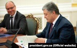 Президент України Петро Порошенко під час підписання закону «Про забезпечення функціонування української мови як державної». Ліворуч від нього – спікер парламенту Андрій Парубій. Києві, 15 травня 2019 року