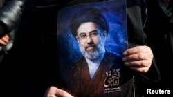 A woman in Tehran on March 9 holds a portrait of Iran's new supreme leader, Mojtaba Khamenei, at a gathering to support his appointment amid the US-Israeli war with Iran.