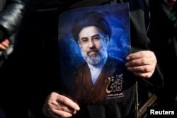 A woman in Tehran on March 9 holds a portrait of Iran's new supreme leader, Mojtaba Khamenei, at a gathering to support his appointment amid the US-Israeli war with Iran.