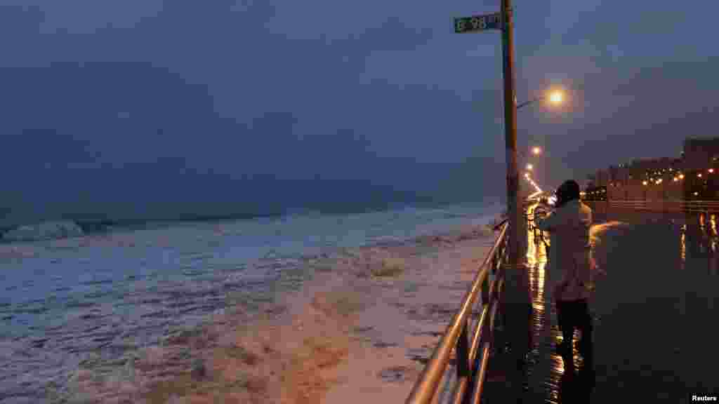 A woman takes a photo at Beach 98th street on the boardwalk at Rockaway Beach in the Queens borough of New York.&nbsp;