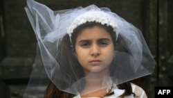 A young actress plays the role of a child bride during a protest organised by Amnesty International to denounce child marriage, on October 27 in Rome.