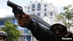  Проруски деятел насочва револвер против шествието на украинските националисти в Одеса, 2 май 2014 година 
