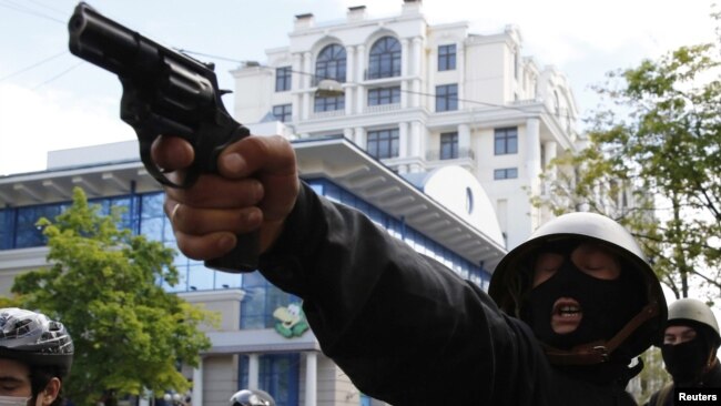 Проруски активист насочва пистолет срещу шествието на украинските националисти в Одеса, 2 май 2014 г.