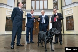 Старое здание резиденции в Ново-Огарёве. На фото чиновники и конструкторы стоят вокруг вокруг собаки Кони с устройством ГЛОНАСС-GPS в ошейнике. 17 октября 2008 года