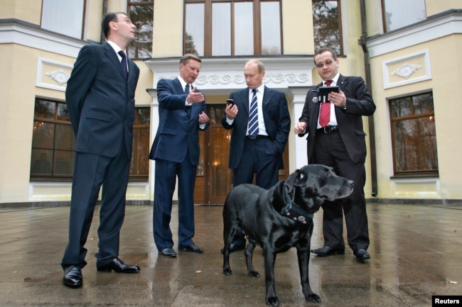 Ndërtesa e vjetër e banimit në Novo-Ogaryovo. Në këtë foto, zyrtarë dhe projektues qëndrojnë rreth Konit, një qen me një pajisje GLONASS-GPS të lidhur në jakë. 17 tetor 2008.