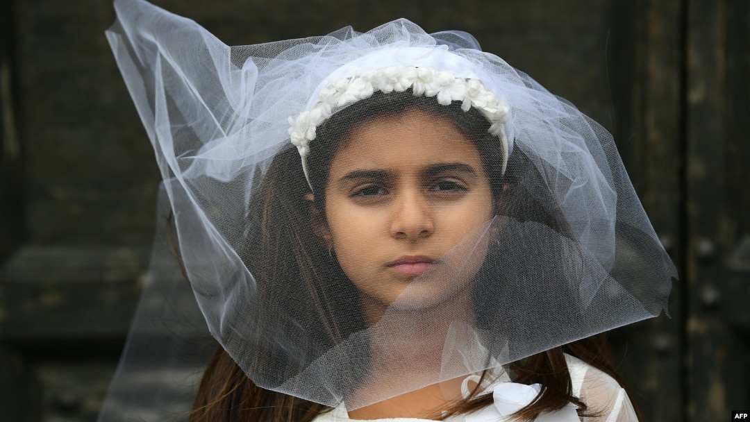 A young actress plays the role of a child bride during a protest organised by Amnesty International to denounce child marriage, on October 27 in Rome.