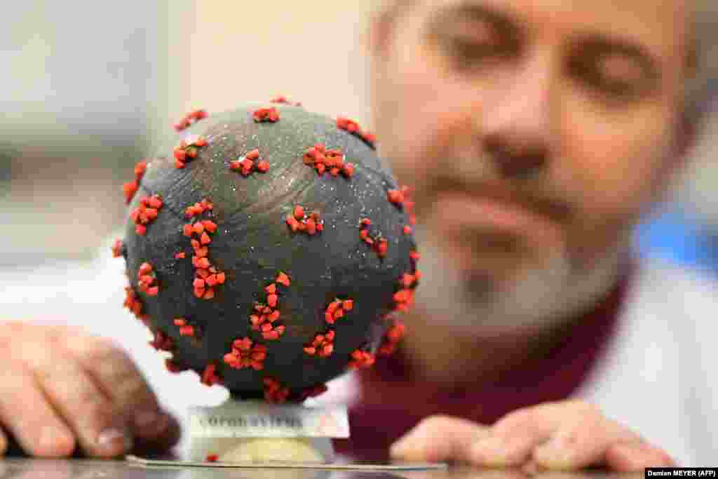 French chocolate maker Jean-François Pre shows an Easter egg shaped like the coronavirus in his shop in Landivisiau. It&#39;s made using white chocolate with black and red-colored almonds.