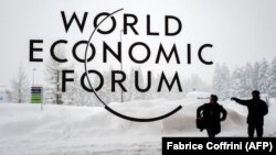 SWITZERLAND -- A security guard show the way to a man outside of the Davos Congress Centre under snow ahead of the opening of the World Economic Forum (WEF) 2018 annual meeting, in Davos, January 22, 2018