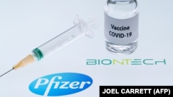 Шприц и ампула надписью «Вакцина COVID-19» рядом с логотипами американской компании Pfizer и немецкой Biontech.