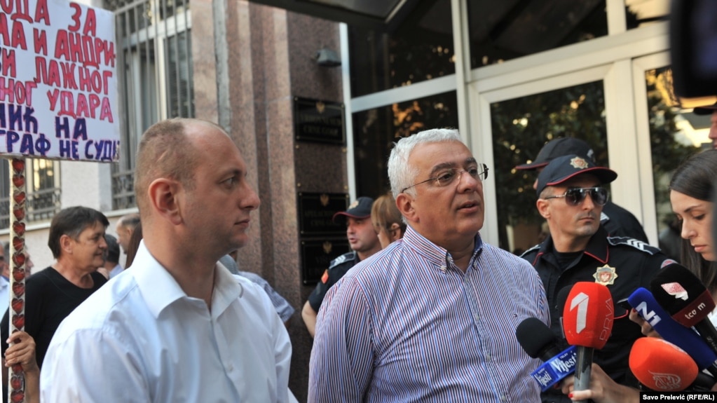 Montenegrin oppositionists Andrija Mandic (right) and Milan Knezevic meet with supporters as they arrive for a court hearing in Podgorica on July 20.