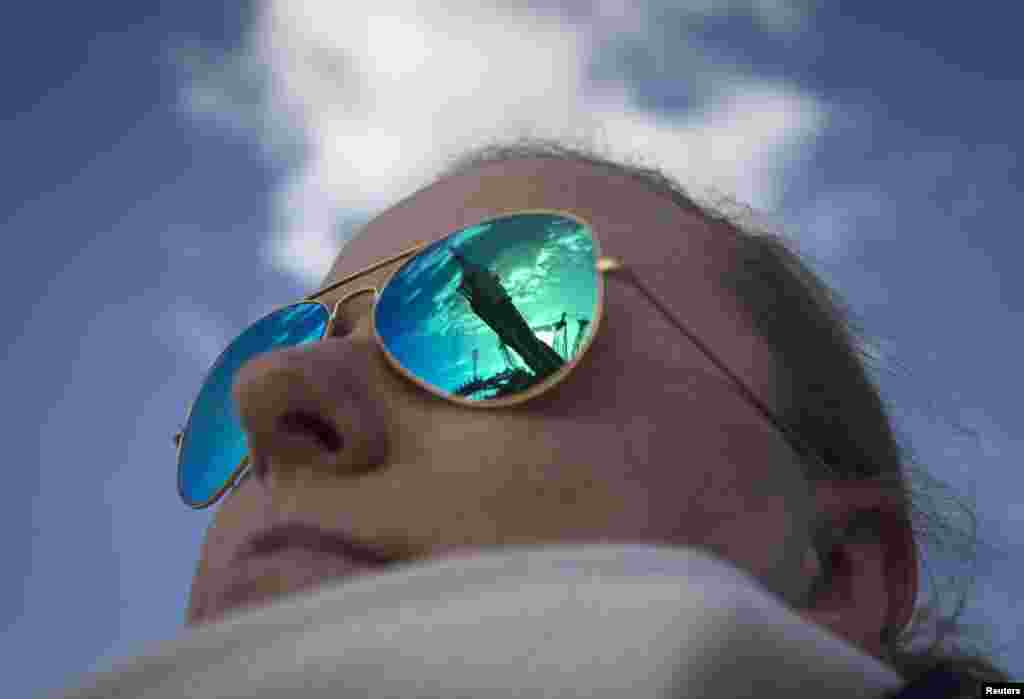 A woman watches the Soyuz TMA-14M spacecraft as it is reflected in her sunglasses at Kazakhstan&#39;s Baikonur cosmodrome. The Soyuz is scheduled to carry Barry Wilmore of the U.S. and Elena Serova and Alexander Samokutyaev of Russia to the International Space Station on September 26. (Reuters/Shamil Zhumatov) 