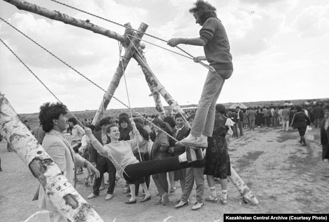 Naýryz meıramy kezinde altybaqan teýip júrgen jastar. Qaraǵandy qalasy, 1988 jyl. Foto avtory - V. Petýhov. Sýret Qazaqstan ortalyq memlekettik kınofotoqujattar jáne dybys jazbalar arhıvinen alynǵan