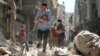 Bărbații sirieni care-și croiesc drum printre dărâmături, cu bebeluși salvați în urma unui atac aerian asupra cartierului Salihin din orașul Alep, în septembrie 2016