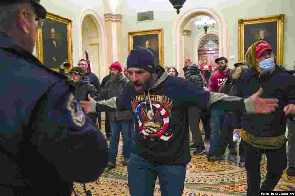 Manifestanți agresivi pro-Trump față în față cu reprezentații poliției, pe holul de lângă sala de ședințe a Senatului american.