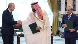 Türkiyə prezidenti Rəcəb Tayyib Ərdoğan Məkkədə birgə müdafiə sazişini imzaladıqdan sonra Pakistan baş naziri Şahbaz Şərifin baxışları altında Səudiyyə Ərəbistanının Vəliəhdi Məhəmməd bin Salman ilə əl sıxışır.