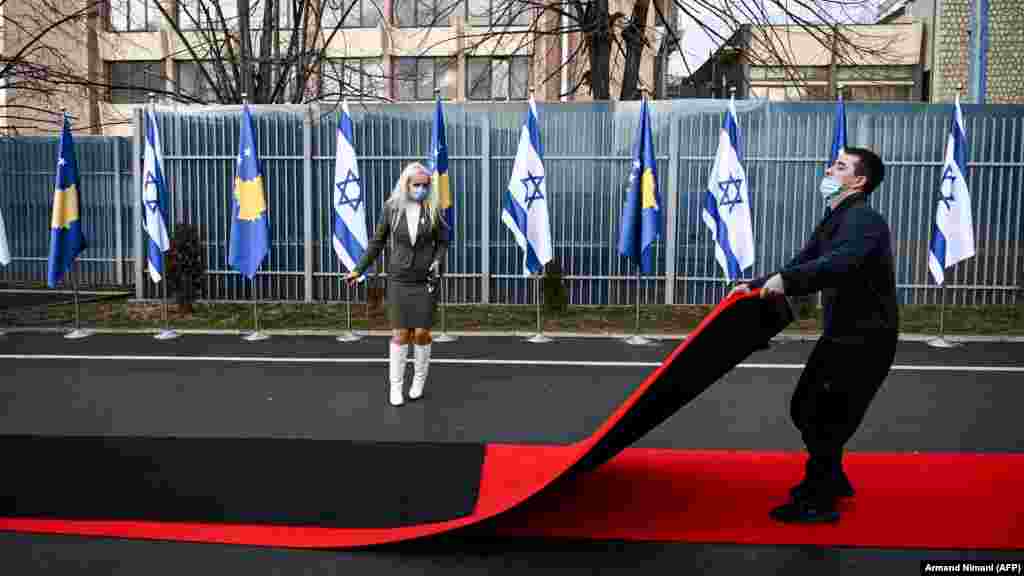 Postavljanje crvenog tepiha pored zastava Kosova i Izraela istaknutih na ceremoniji ispred sjedišta Ministarstva vanjskih poslova u Prištini, 1. februar. (Armend NIMANI / AFP)