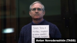 Paul Whelan holds up a sign at his court hearing in Moscow on June 15.