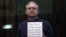 Paul Whelan holds up a sign at his court hearing in Moscow on June 15.