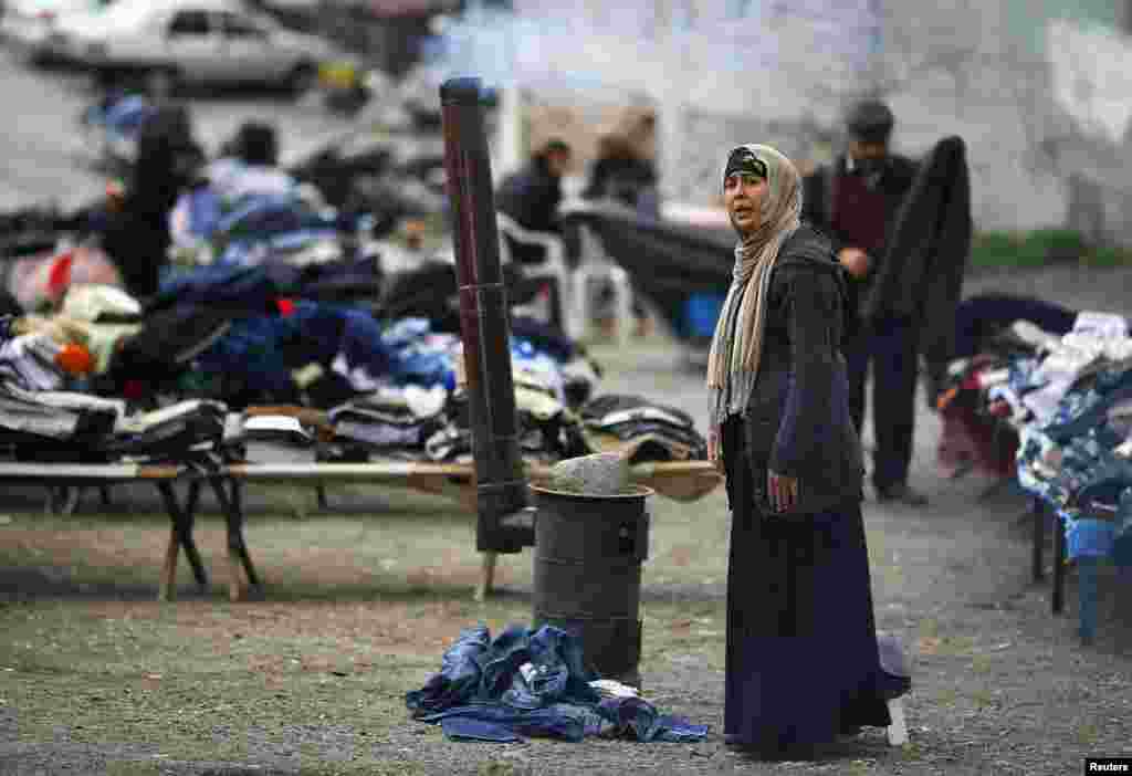 A street vendor woman warms herself as she stands by a stove in Ankara. (Reuters/Umit Bektas)