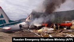 Firefighters work on extinguishing a fire on an An-24 passenger plane at Nizhneangarsk airport on June 27.