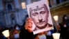 ITALY – A protester holds a picture of Russian President Vladimir Putin with a moustache and a symbol of swastika to resemble the Nazi dictator Adolf Hitler. Italy, February 25, 2022