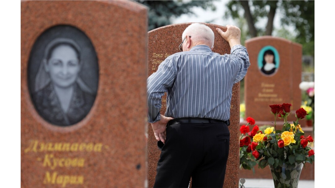 A man mourns at the cemetery where victims of the 2004 school siege are buried on the 15th anniversary of the siege in the southern Russian town of Beslan on September 2, 2019.